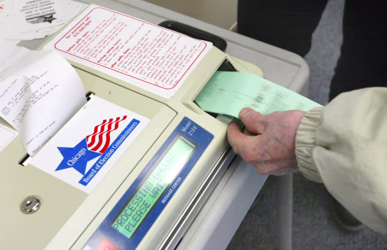 A voter submits his ballot to a punch-card reader in Chicago during a primary election in March.