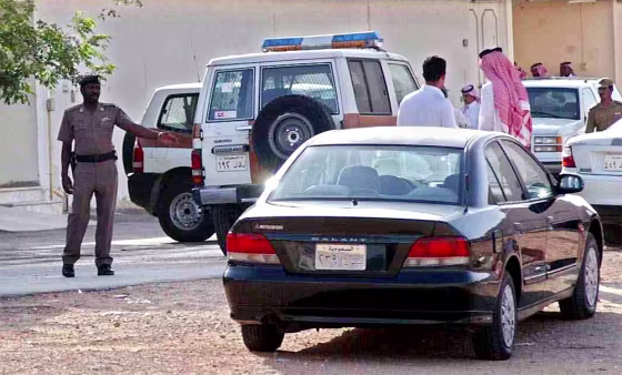 Saudi police and neighbors of the Riyadh neighborhood stand outside the building&nbsp;where an American was killed Tuesday.