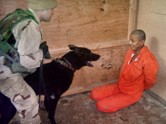 In this undated still photo, an Iraqi detainee appears to be intimidated by a U.S. soldier using a trained dog inside the Abu Ghraib prison, west of Baghdad.