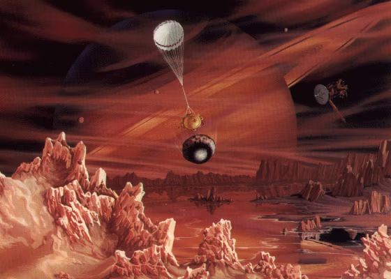 An artist's conception shows the Huygens probe dropping toward the surface of Titan, Saturn's largest and most mysterious moon. In the background, the artwork shows the Cassini orbiter and Saturn itself.