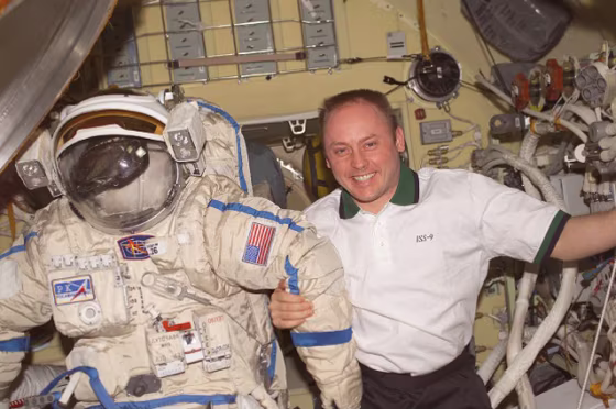 U.S. astronaut Mike Fincke stands next to his spacesuit aboard the international space station.