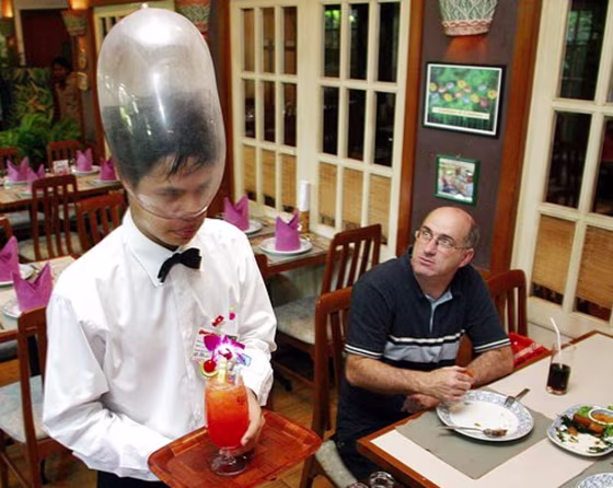 A Thai waiter wears a condom on his head at Bangkok's Cabbages and Condoms restaurant, founded by Mechai Viravaidya to promote safe sex education. Mechai said the government must take new steps against AIDS. 