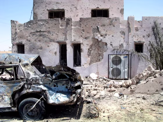 A vehicle used in a car bombing sits upended next to a police station Thursday in Haditha, Iraq.&nbsp;The blast killed 10 people in a second day of violence.