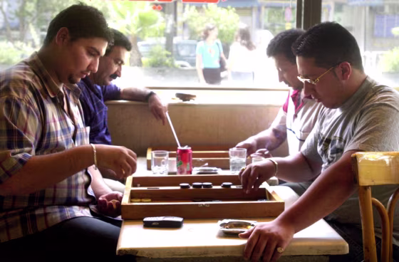 Iraqi businessman Waed Jassem, second from left wearing a blue shirt, plays backgammon with one of his relatives in a cafe in Damascus, Syria, in this July 22 photo. This summer, Iraqis have flocked to Syria; the toppling of Saddam Hussein has made it easier to travel and do business.