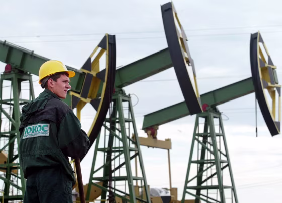 A worker from Russian oil firm YUKOS looks over derricks at a major oil processing facility