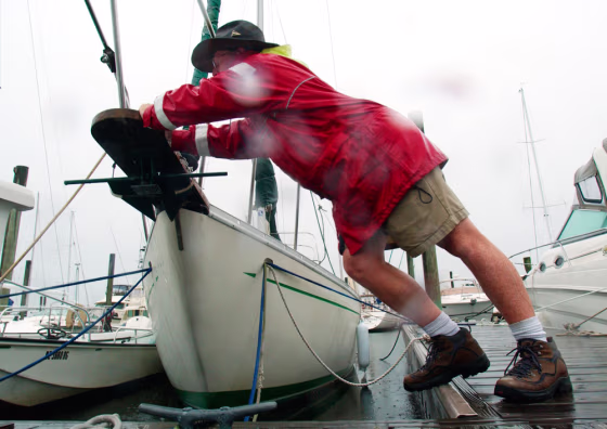 Dockmaster Bill Whaley pushes a boat as he adjusts lines in preparation for the arrival of Hurricane Charley in Wrightsville Beach, N.C., on Saturday.