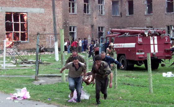 Volunteers carry an injured civilian to safety in the town of Beslan