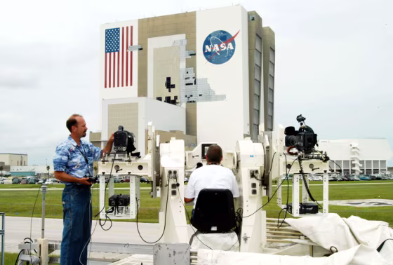 Kennedy Space Center&nbsp;videographer Glenn Benson adjusts a high-definition camera being used to photograph the south wall of NASA's Vehicle Assembly Building, which sustained damage from Hurricane Frances as it passed over central Florida during the Labor Day weekend.