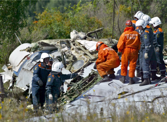 In this file photo, workers search the crash site of one of the planes downed in late August by Chechen bombers, who bribed their way onto the flights.