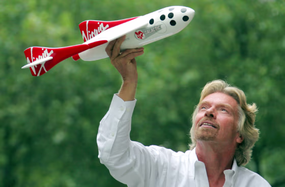Sir Richard Branson holds model of a spacecraft at a news conference in central London