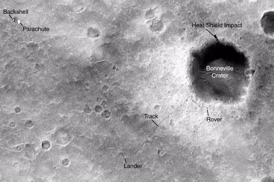 An image acquired&nbsp;by the Mars Global Surveyor and released Monday shows a dark dot identified as the rover Spirit next to giant Bonneville Crater and the thin dark line of its tracks leading back to its lander.