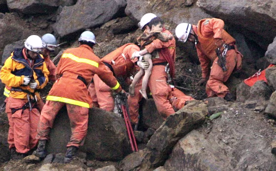 Rescuers remove Yuta Minagawa, 2, from a car buried in a landslide in Nagaoka on Wednesday.