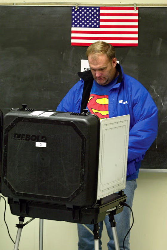 Firefighter Scot Hopkins votes early on a touch-screen voting machine at the Jackie Robinson Center in Pasadena, Calif., on Oct. 20.