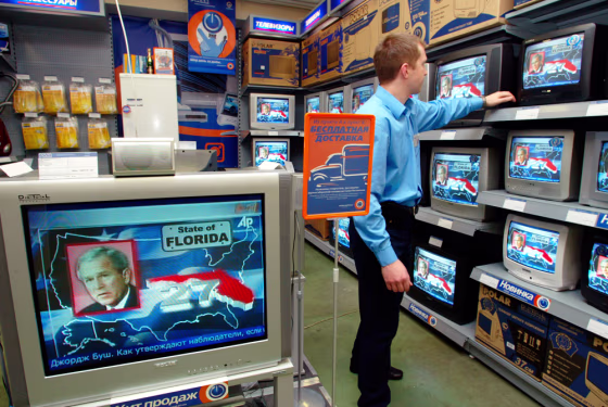 A shop assistant watches TV news about the U.S.&nbsp; elections in a Moscow shop on Wednesday.