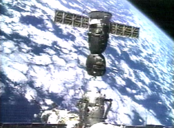In an image take from video, the Soyuz crew capsule separates from the international space station to move to another docking port, against the background of a cloud-mottled Earth.