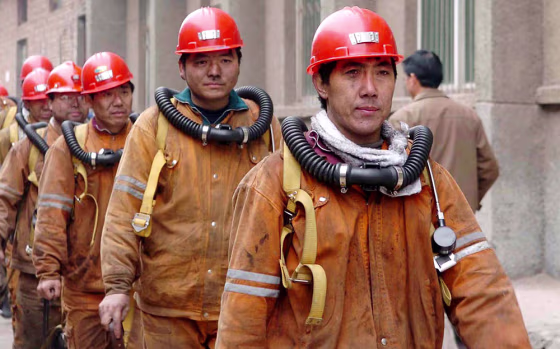 Chinese rescuers emerge from the underground tunnel in Chenjiashan