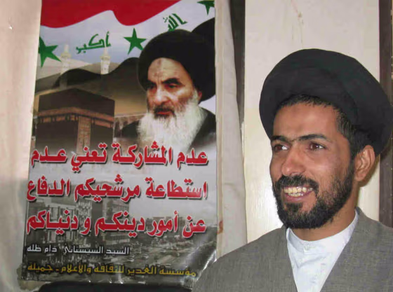 Sayyid Hashem Awadi stands in front of&nbsp;a poster of Grand Ayatollah Ali Sistani, Iraq's preeminent religious figure who wields great influence over Shiite involvement in the upcoming election.