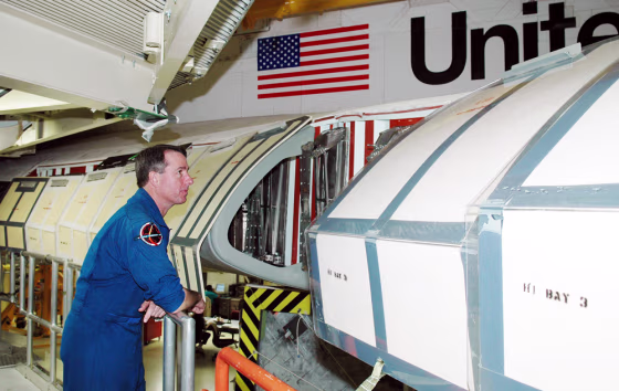 A crew member for the next shuttle mission,&nbsp;Stephen Robinson, looks inside the wing of the&nbsp;shuttle Discovery, which is in the Orbiter Processing Facility at NASA's Kennedy Space Center for launch processing. Discovery is scheduled for launch&nbsp;no earlier than&nbsp;May 12.