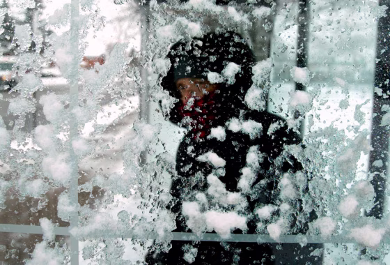 A woman peers through a snow-covered bus shelter as she waits for her ride on Chicago's north side earlier this month.&nbsp;Winter could get even more depressing on Monday, according to a British researcher.