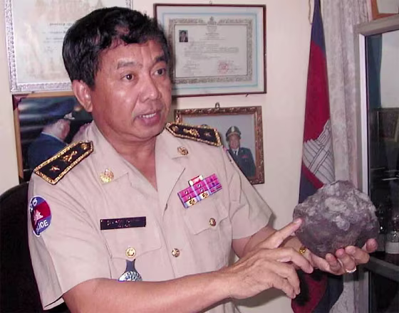 Police chief shows a 10 lb meteorite rock which landed in a former Khmer Rouge zone, northwest Cambodia