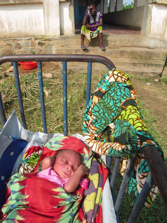 Nsimenya Kinyama, 36, sits near her newborn son, who is not yet named, outside the maternity ward at the hospital in Shabunda, Congo. Kinyama has watched all six of her previous children die.