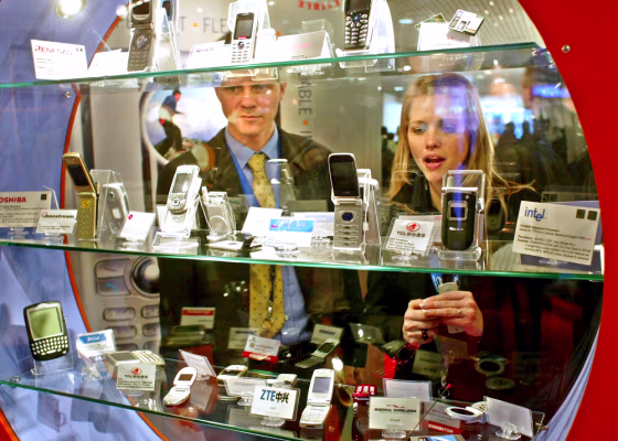 Visitors look at smartphones during the 3GSM World Congress 2005 in Cannes, France on Monday.