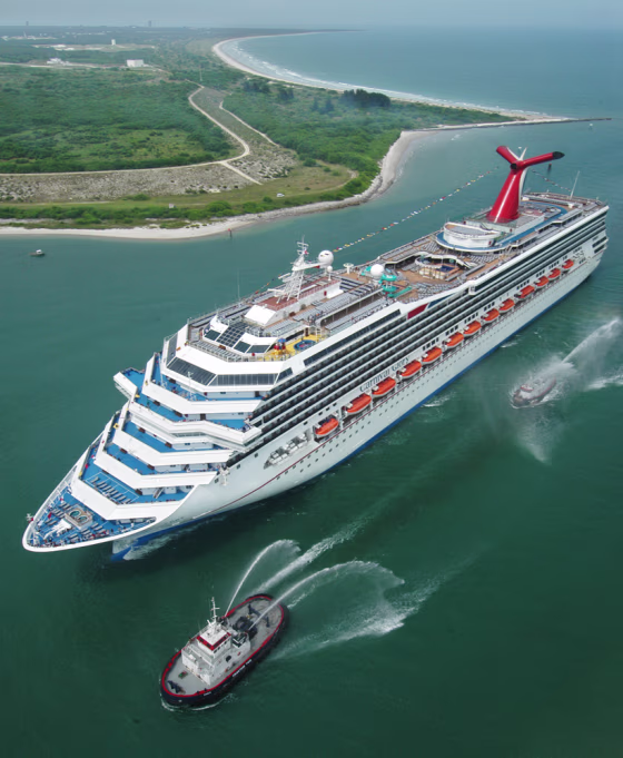 Escorted by water-squirting tugs, the new Carnival Glory passes the Kennedy Space Center as she arrives in Cape Canaveral, Fla., on&nbsp;July 11, 2003. Carnival, the world's largest cruise company, had its most profitable year ever in 2004 and expects to do better this year.