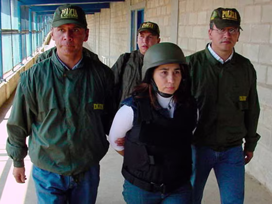 This photo released by Colombia's National Police shows police agents escorting guerrilla commander Omaira Rojas, known as Sonia, center, before she was flown Wednesday from a maximum security jail in northern Colombia to the United States.