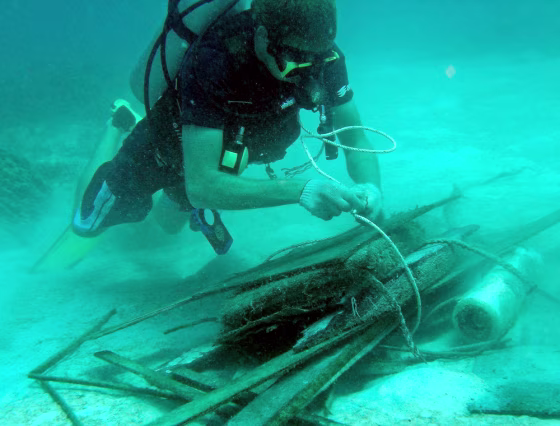 A volunteer diver ties debris to be lifted out of coral and sea bed near Koh Phi Phi island