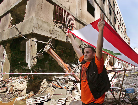 An anti-Syrian protester carries a Lebanese flag on Sunday at the site of the explosion in an industrial zone of the mainly Christian neighborhood in Beirut. 