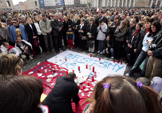 Polish pilgrims gather next to&nbsp;their national flag Sunday as thousands of people crowd St. Peter's Square in Rome during a Mass for the repose of Pope John Paul II's soul.&nbsp;