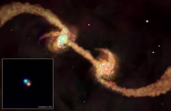 The illustration shows two young galaxies in the process of merging. The merger has triggered a burst of star formation and is providing fuel for the growth of the galaxies' central supermassive black holes. 
