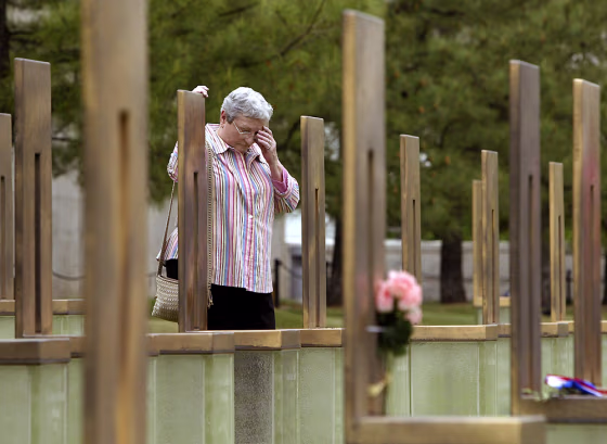 Woman reacts at daughters memorial chair at Oklahoma City National Memorial on eve of bombing anniversary
