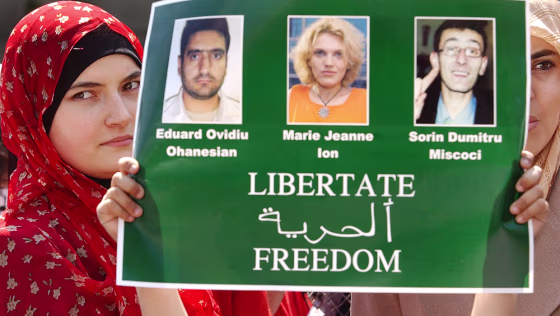 Women of the Romanian Arab community hold a poster showing the three Romanian journalists kidnapped in Iraq, during a protest held in Bucharest, Romania in April.