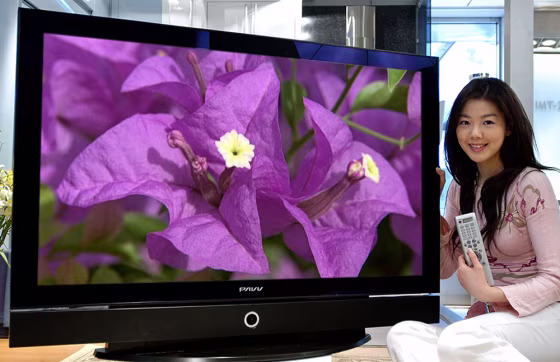 Model poses next to Samsung Electronics' new 50 inch HD PDP TV in this handout picture
