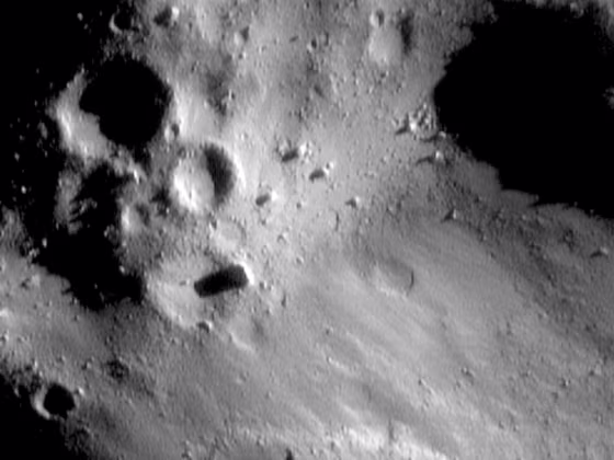 This image shows pooling of regolith and small boulders in low areas of the asteroid Eros, plus degraded craters, nearly erased "ghost" craters and a very few small craters.