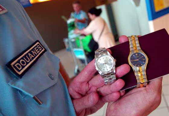 A French customs officer displays two fake Rolex watches discovered in the suitcase of a&nbsp;vacationer coming from Thailand.