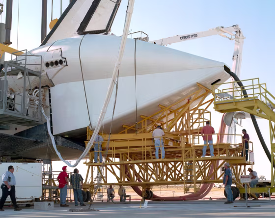 Technicians attach the tail cone to the space shuttle Discovery on Tuesday in preparation for its return to NASA's Kennedy Space Center in Florida.