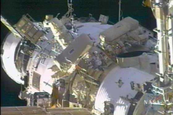 Sergei Krikalev and John Phillips work outside the international space station as it orbits Earth on Thursday.