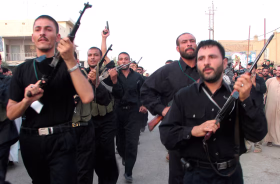 Members of Shi'ite Badr Brigade militia march on anniversary of coalition air strike in southern Iraqi town of Kut