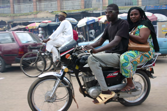 A&nbsp;woman rides a motorcycle taxi in Kano's traffic. Soon, she will be allowed only to use&nbsp;special, woman-only motorcycles.