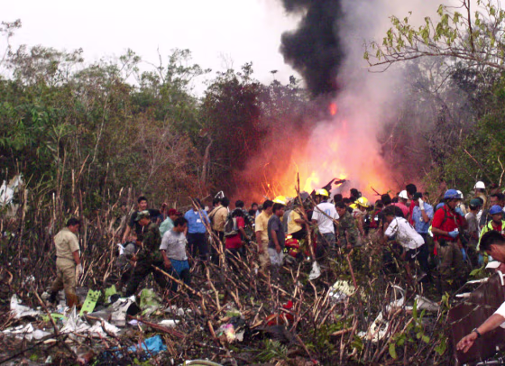 Rescue workers walk amid the debris of a plane crash in the Peruvian jungle in Pucallpa
