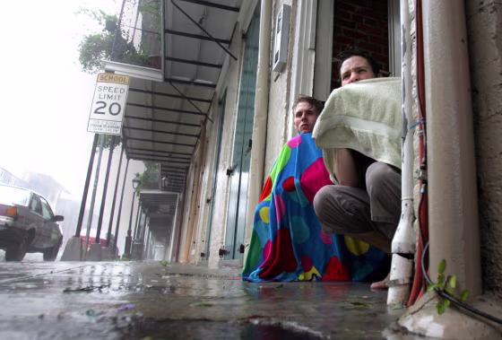 Blair Quintana, right, and Patrick Lampano seek shelter in a doorway in the French Quarter of New Orleans as Hurricane Katrina pounds the Crescent City on Monday.