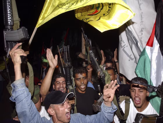 Members of the Palestinian militant group Al Aqsa Martyrs Brigades celebrate after the Israeli army left the northern West Bank Jewish settlement of Qadim on Tuesday.