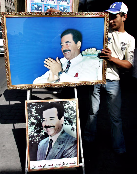 A Jordanian worker displays pictures of&nbsp;former Iraqi leader Saddam Hussein for sale outside his shop in Amman, Jordan, on&nbsp;Tuesday. 