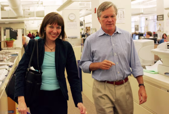 This photo provided by The New York Times shows New York Times reporter Judith Miller, left, walking with&nbsp;Executive Editor Bill Keller after being welcomed back to the newsroom by staff and editors&nbsp;Oct. 3 at the New York Times offices in New York.