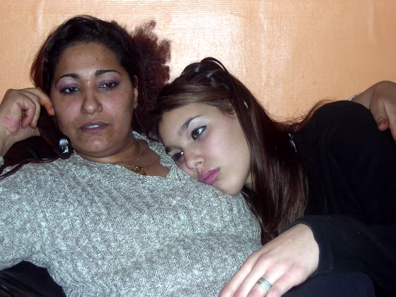 Jenah Benzanfour, 16, rests against her guardian, Manoubia Khalil, left, during a Nov. 7&nbsp;interview at her home in a housing project of Saint-Denis, a suburb north of Paris. If young men in France's poor districts have it rough, girls often have it worse. 