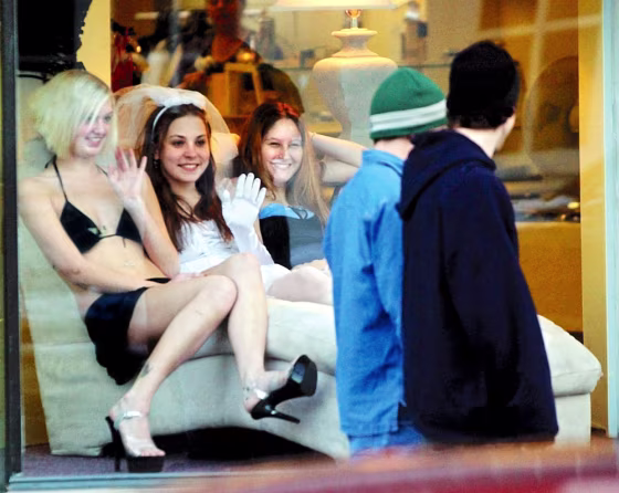Models Tara Manns, left, Jesyka Clark, center, and Amanda Richards wave at passersby on Nov. 25 from a shop window in downtown Augusta, Maine. 