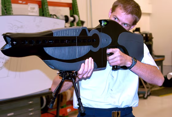 U.S. Air Force Capt. Drew Goettler, at Kirtland Air Force Base, N.M., demonstrates a prototype hand held laser device developed as a non-lethal weapon intended to "dazzle" a potential enemy by temporarily impairing a person's ability to see.