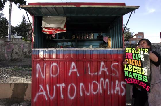 Aymara Indian street vendor Juana Ilasanca sets up her shop in the outskirts of La Paz, Bolivia.&nbsp;Calls for independence are becoming a major election issue as the country heads to the polls this Dec. 18. The graffitti reads "No to the Autonomy." 